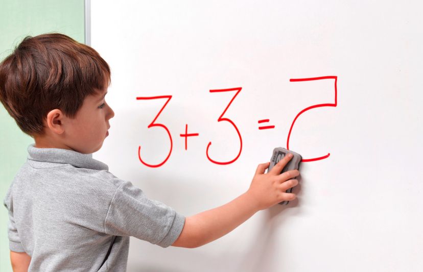 A dyslexic child on board solving math problem.