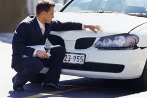 Insurance agent examining car damage