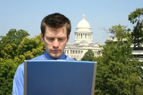 Guy looking at laptop with Capitol in background