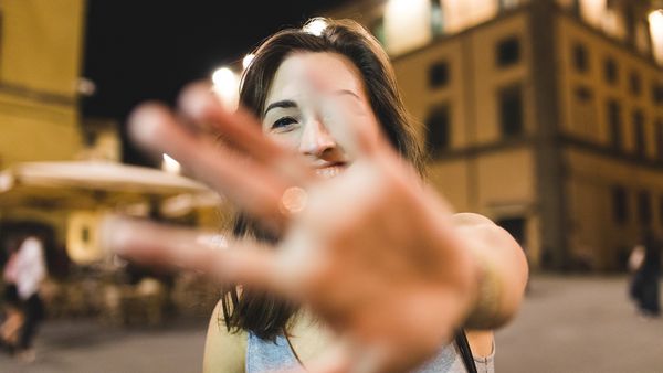 Woman holding hand up in front of camera