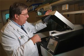Jeffery M. Vance, M.D., Ph.D, department chair of human genetics at the University of Miami, operates Illumina's HiSeq machine. The device completed whole exome sequencing to find the cause of a degenerative eye disease called retinitis pigmentosa.