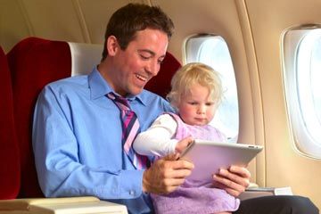 father and daughter on plane with iPad