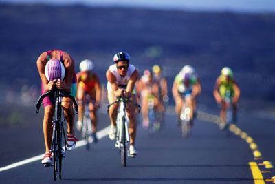 Athlete cycling outdoors on bicycle.