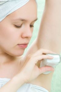 Woman applying anti-perspirant.