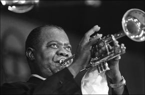 路易斯·阿姆斯特朗（Louis Armstrong）于1965年在巴黎演出。“width=