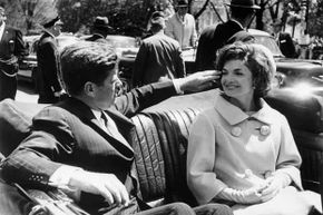 In happier times, JFK fixes Jackie's windblown hair on a ride between the White House and Blair House in 1961.