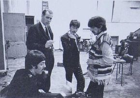 Producer George Martin keeps his eyes on the camera, while “the boys” listento Paul’s run-through of a bass part during the Sgt. Pepper sessions.