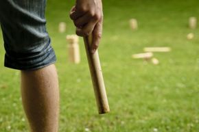 A player prepares to throw a baton in a game of kubb.