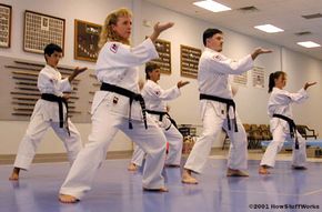 Advanced karatekas at Karate International of Raleigh practice their stances. (L-R) Michael Tuso is a first-degree black belt, Kathy Olevsky is a sixth-degree black belt, John Elliott is a third-degree brown belt, Tony Letourneau is a fourth-degree black belt and Mindy Mayernik is a third-degree black belt.