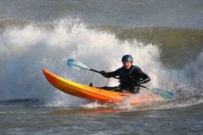 Man in kayak rides wave