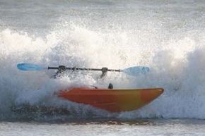 Wave crashes over man in kayak