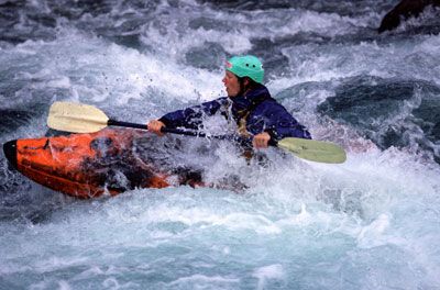 Person adventuring outdoors with oar for extreme sports.