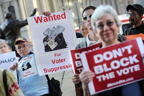Demonstrators hold signs during a rally against voter ID laws, Sept. 13, 2012 in Philadelphia.