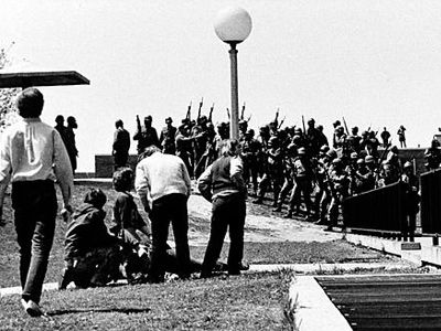 Men in large black and white crowd outdoors.