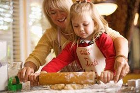 A mother and daughter roll out cookie dough together.