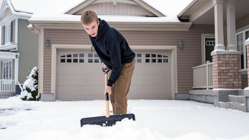 十几岁的男孩铲雪”width=