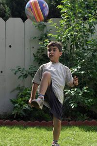 boy bouncing a soccer ball on his knee