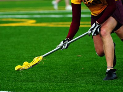 Womens lacrosse player scooping up the ball for a turn over.