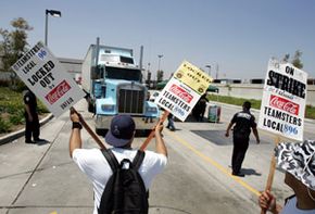 A truck driven by a replacement worker moves Coca-Cola soft drinks to market during a 2005 strike in California.