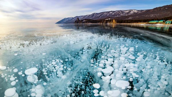 Nature's majestic blue mountains over a frozen water landscape.