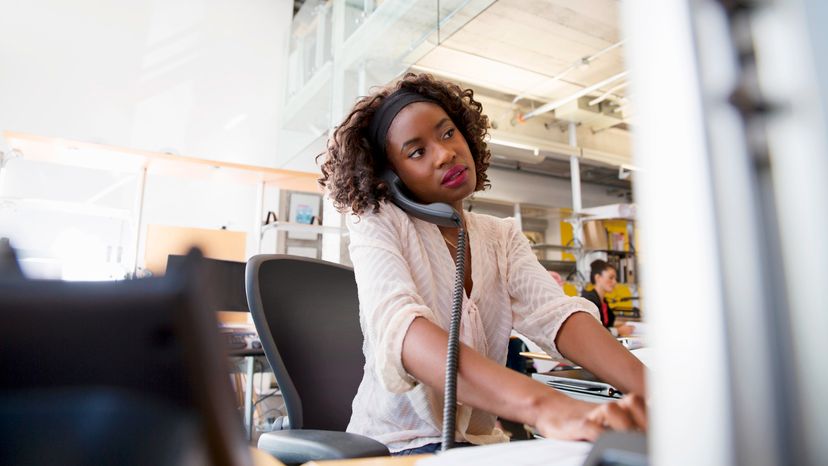 Woman on landline phone working in office