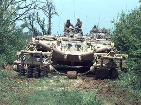 A remotely controlled Panther armored mine-clearing vehicle leads a column of armored vehicles down a road near McGovern Base, in Bosnia-Herzegovina on May 16, 1996.