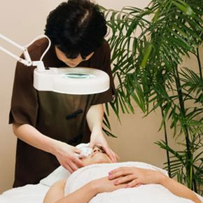 Woman receiving facial skin care treatment.