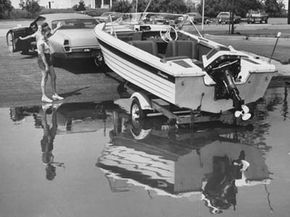 A couple works together to launch a boat from a trailer.