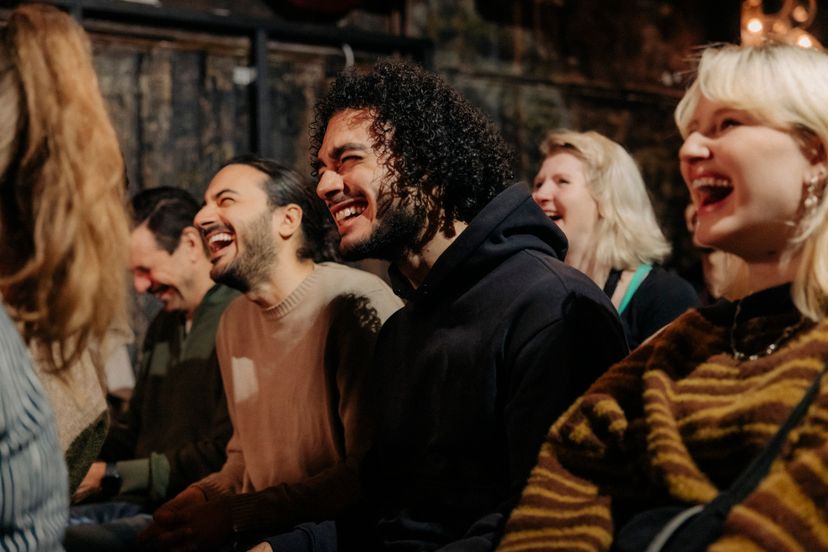 Multiracial audience laughing while enjoying comedy show at amateur theater