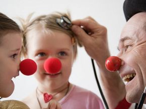 doctor dressed as clown with two young patients