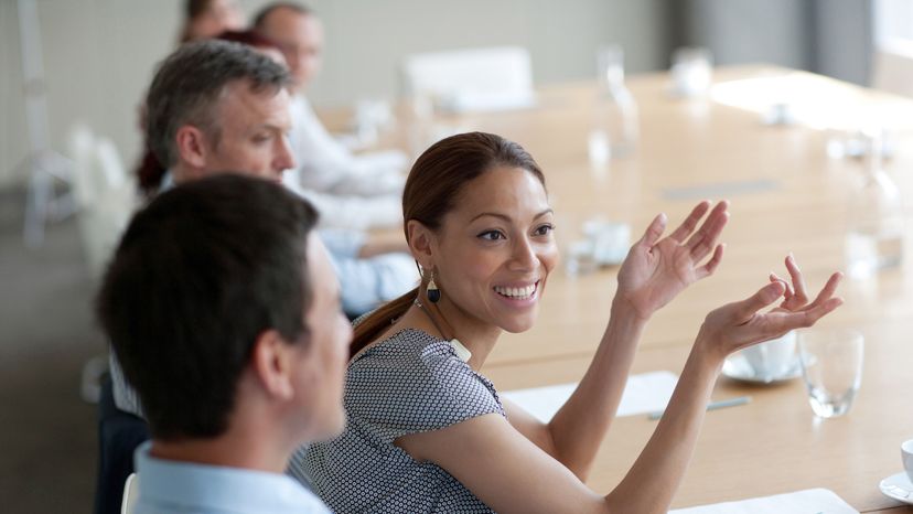 A woman having a business meeting with her colleagues around a conference table 