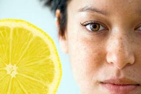 Girl with freckles, lemon slice in background.