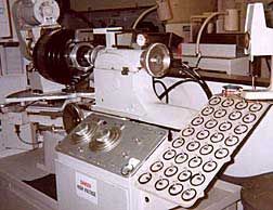 A compound grinder, called a generator, grinds the required curves into the back of the lens blank. The two large dials on the console set the spherical and cylindrical curves that will be ground into the lens.