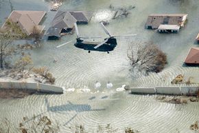 A helicopter drops sand bags to plug a levee break in New Orleans following the landfall of Hurricane Katrina in 2005.