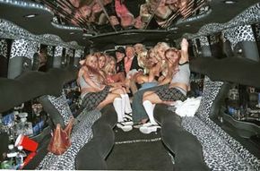 Hugh Heffner and friends pose in the highly stylized Playboy limousine. A swank limo interior with neon lighting