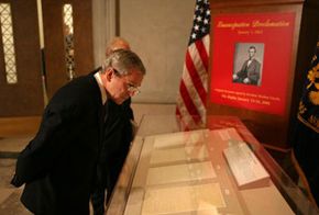 President George W. Bush looks over the Emancipation Proclamation on display at the National Archives Jan. 16, 2006, in Washington, DC. The document is rarely displayed due to its fragile condition.