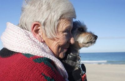senior woman with her dog on beach