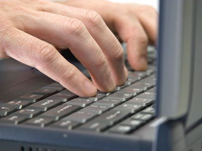 man typing on keyboard