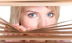 woman peering through blinds