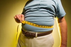 man measuring his big belly with tape