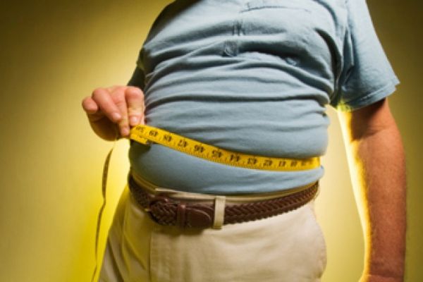 man measuring his big belly with tape