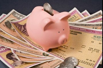 piggy bank on top of savings bonds