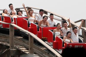 Newly married couples ride a roller coaster during their wedding ceremony at the Happy Valley theme park in Wuhan, China. Some couples enjoyed the ride more than others.
