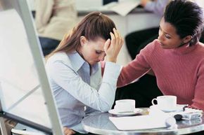 woman consoling another in coffee shop