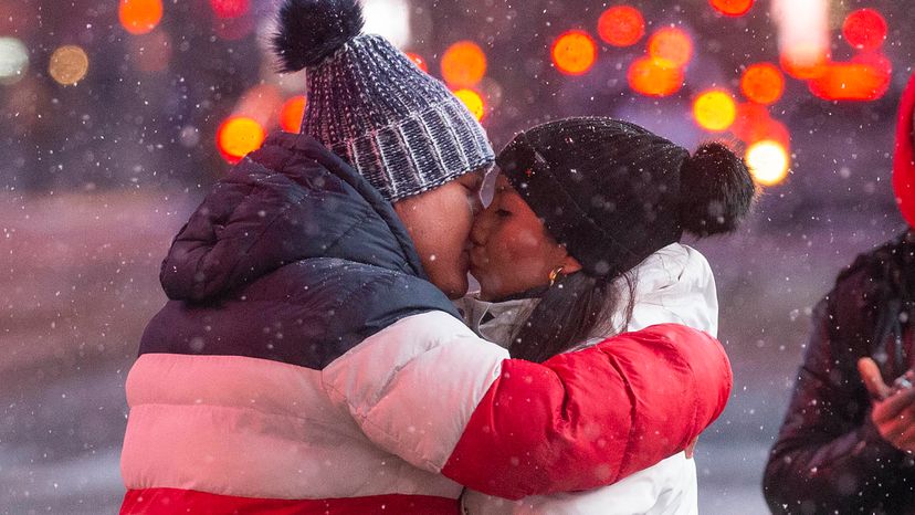 A couple kiss each other as snow falls during a winter storm in Times Square New York on January 31, 2021. 