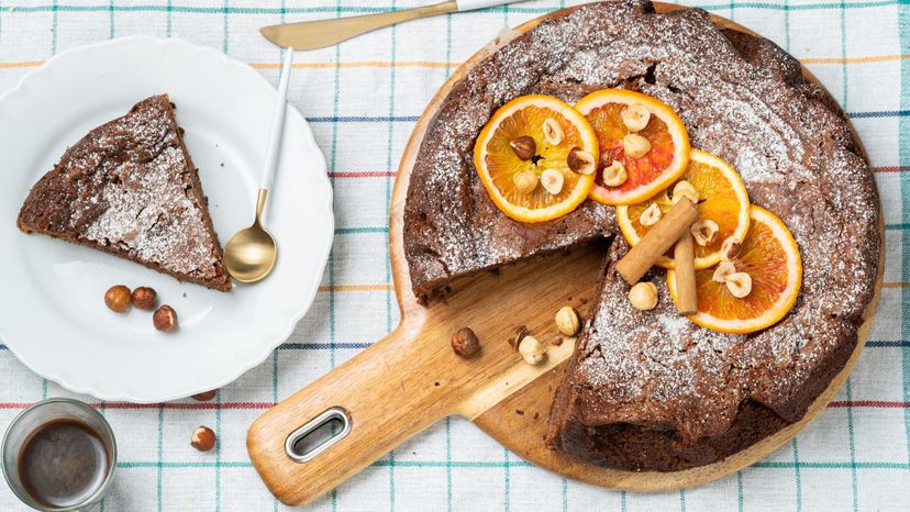 A cake decorated with dried red orange and cinnamon stick