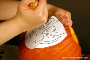 Use a sharp tool to transfer the stencil to the pumpkin's surface.