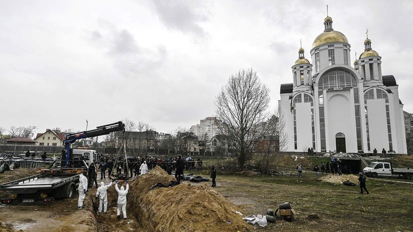Ukrainian investigators exhume bodies from a mass grave in Bucha, Ukraine, in April 2022.