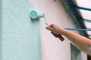 Paint being applied to stucco with roller