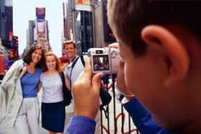 A young boy takes a picture of his family in Times Square.